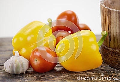 Bell peppers, tomatoes and garlic on wood Stock Photo