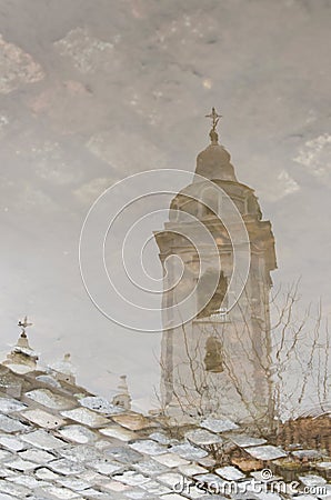 Bell tower of the Basilica of Our Lady of Pillar reflected in a puddle of water Stock Photo