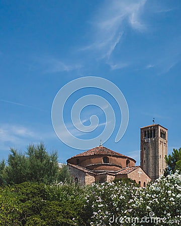 Bell tower of Cathedral of Santa Maria Assunta and Church of Santa Fosca over trees in Torcello, Venice, Italy Stock Photo