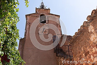 Bell tower of fortress with clock and red ochre stone wall Roussillon in Provence France Stock Photo