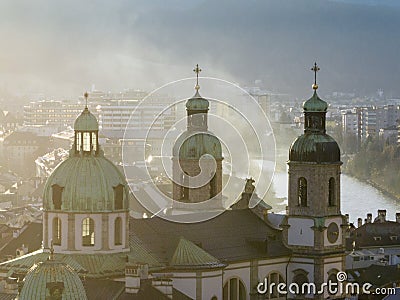 Bell towers of Cathedral of St. James in Innsbruck, Austria. Church Domes in Soaft Light at Foggy Evening sunset time Stock Photo