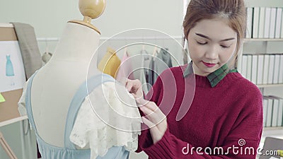 Belle robe de mesure fonctionnante femelle asiatique professionnelle de couturier sur une conception d'habillement de mannequin a Belle robe de mesure fonctionnante femelle asiatique professionnelle de couturier sur une conception d'habillement de mannequin a