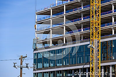 BELLEVUE, USA – MAY 3, 2023: Spring District, under construction, crane loading in new window to workers ready to install Editorial Stock Photo