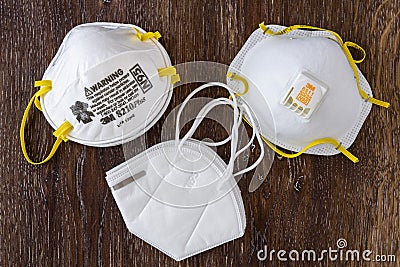 BELLEVUE, WA/USA â€“ APRIL 18, 2020: PPE safety supplies on a wood table, three different N95 masks Editorial Stock Photo