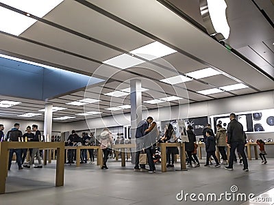 Technology crazed people shopping inside an Apple store for the latest iPhones and Editorial Stock Photo