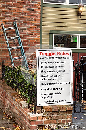 A Sign Doggie Rules outline expected puppy behavior at local restaurant Editorial Stock Photo