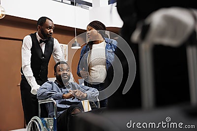 Bellman transfer wheelchair user to room Stock Photo