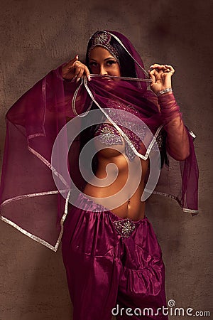 Belly-dancer woman in afghani pants, purdah and adornment Stock Photo