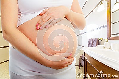 Belly of a pregnant woman in the bathroom Stock Photo