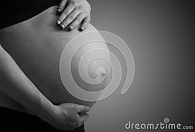 Belly of pregnant woman monochrome on dark background Stock Photo