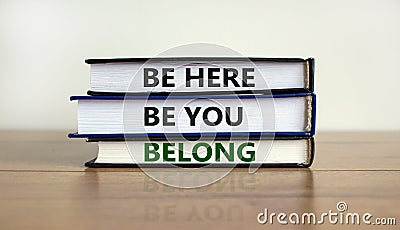 Belong symbol. Books with words `be here, be you, belong` on beautiful wooden table, white background. Business, belonging and Stock Photo