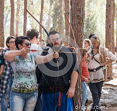 Member of the annual reconstruction of the life of the Vikings - `Viking Village` teaches visitor how to shoot arrows in the fores Editorial Stock Photo