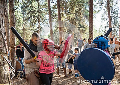 The reconstruction participant of the `Viking Village` teaches children swordfighting in the camp in the forest near Ben Shemen in Editorial Stock Photo
