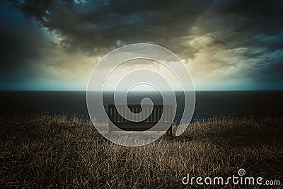 Bench in front of a dramatic cloudscape Stock Photo