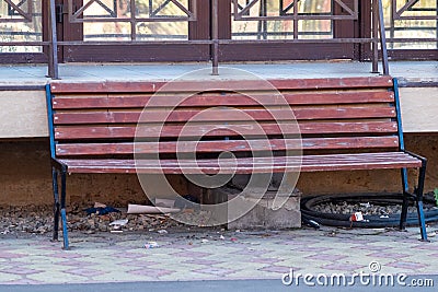 Bench and garbage under it. a plastic glass under a bench Stock Photo