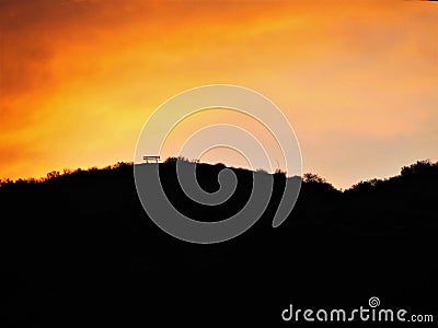 Bench on a Hill with Orange Glowing Sky Stock Photo