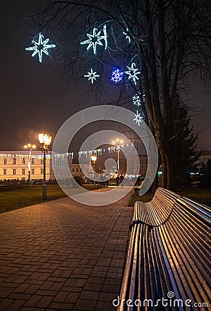 Bench in misty city park at night Stock Photo