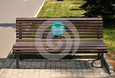 bench in a park with an anti-covid inscription in russian language minimum distance 1.5 meters Editorial Stock Photo