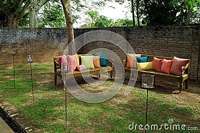 Benches with cushions in garden Stock Photo