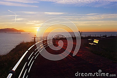 Benches in La Galea park in Getxo at sunset Stock Photo