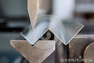 Bending of galvanized sheet metal on a hydraulic bending machine at the factory Stock Photo