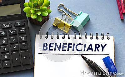 BENEFICIARY word is written in a notebook with a marker, calculator, clamps and cactus Stock Photo