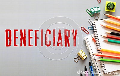 BENEFICIARY word is written in a notebook with a marker, calculator, clamps and cactus Stock Photo