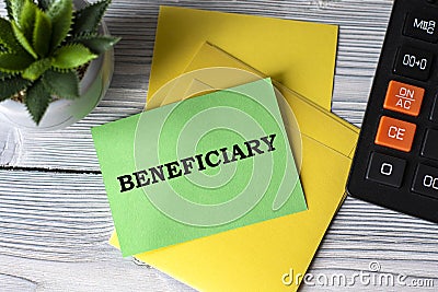 BENEFICIARY - words on green paper on the background of a calculator, and a cactus Stock Photo