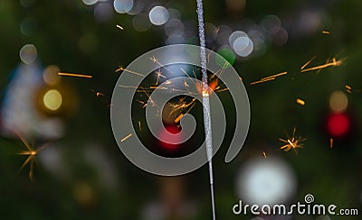 Bengal lights with flying sparks on the background of a Christmas tree Stock Photo