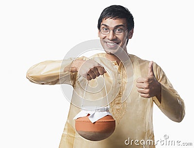 Bengali man carrying a pot of rasgulla and showing thumbs up sign Stock Photo