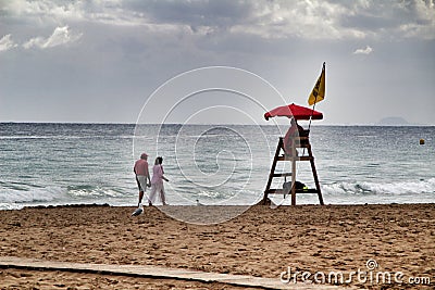 Beach watcher under red umbrella on the beach Editorial Stock Photo