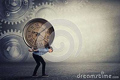 Bent down guy carrying a big heavy clock on his back. Overloaded student tired of daily tasks, and difficult burden. Time pressure Stock Photo