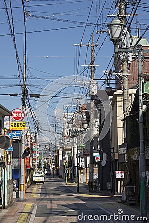 Small street in the centre of the city of Beppu with signs and lots of electricity wires Editorial Stock Photo