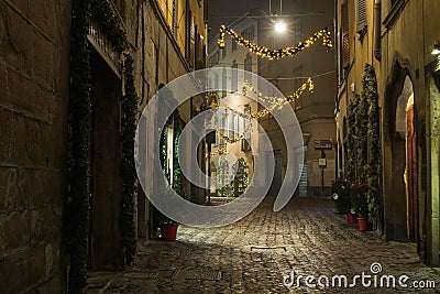 BERGAMO, ITALY - 12, JANUARY. Old European narrow empty street of medieval town with Christmas decoration on a foggy Editorial Stock Photo