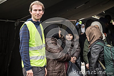 NGO Volunteer standing with a family with a baby waiting to cross the Serbia Croatia border in Berkasovo Bapska Editorial Stock Photo