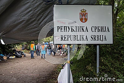 Refugees gathering behing the border sign on Serbia Croatia boundary in Berkasovo Bapska, on Balkans Route, during Refugee Crisis Editorial Stock Photo