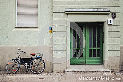 Entrance of a residential building in Berlin, green facade of a house and a bike Editorial Stock Photo