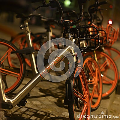 Parked rentable bikes in downtown Berlin, Germany. The bikes are standing in the light of a lantern at evening Editorial Stock Photo