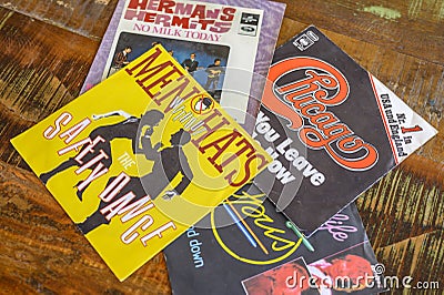 Some record covers from the sixties to the eighties on a wooden table Editorial Stock Photo