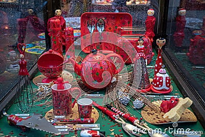 Ornate red painted teapot and crockery utensils with Christmas decorations at showcase of souvenir shop in Europe. Shop window Editorial Stock Photo