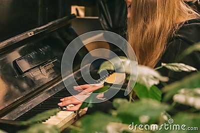 Beautiful hands with long fingers of a girl with black varnished nails playing piano Editorial Stock Photo