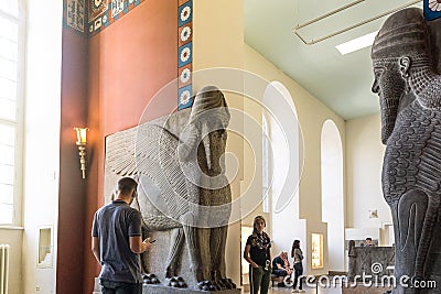 BERLIN, GERMANY - SEPTEMBER 26, 2018: Bright picture of visitors looking at statue exhibitions of Lamassu, an Assyrian Editorial Stock Photo