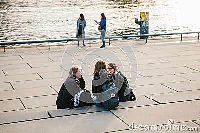 Berlin, October 3, 2017: A group of young girls friends of students sitting on the waterfront which is located near the Editorial Stock Photo