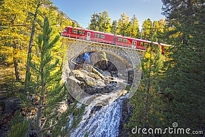 The Bernina Express on the Morteratsch Bridge Editorial Stock Photo