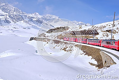 Bernina mountain pass. The famous red train is crossing the white lake. Amazing landscape of the Switzerland land. Famous Editorial Stock Photo