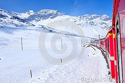 Bernina mountain pass. The famous red train is crossing the white lake. Amazing landscape of the Switzerland land. Famous Editorial Stock Photo
