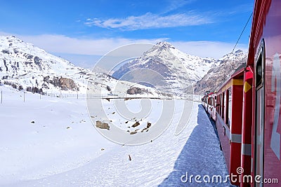 Bernina mountain pass. The famous red train is crossing the white lake. Amazing landscape of the Switzerland land. Famous Editorial Stock Photo