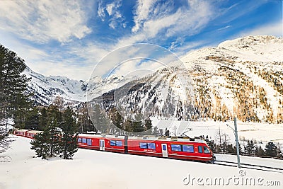 Bernina tourist red train pass on the Swiss Alps Editorial Stock Photo