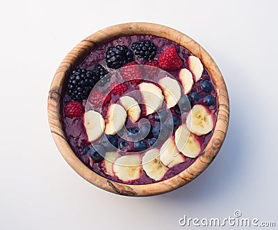 Berry acai smoothie bowl in a wooden bowl topped with bananas, blueberries, blackberries and raspberries Stock Photo