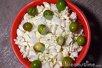 Berry and chopped cauliflower kept in a red colored basket used for vegetable and salad Stock Photo